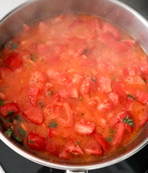 tomatoes melting into a sauce in the skillet