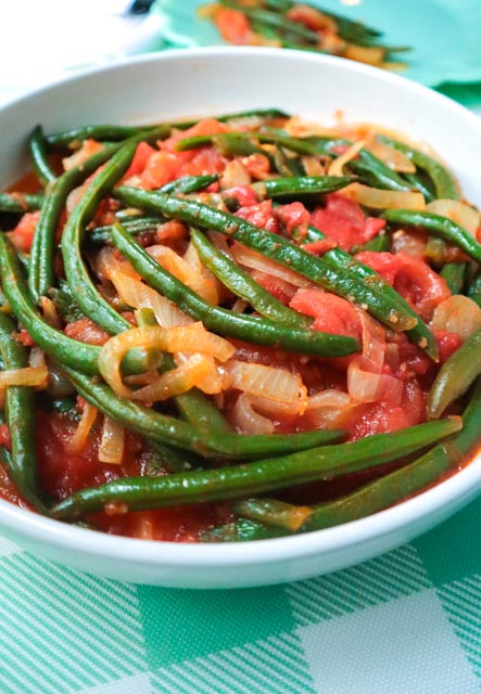 serving bowl with string beans with tomato onion and garlic